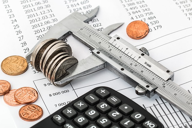Calculadora y monedas sobre hoja de contabilidad